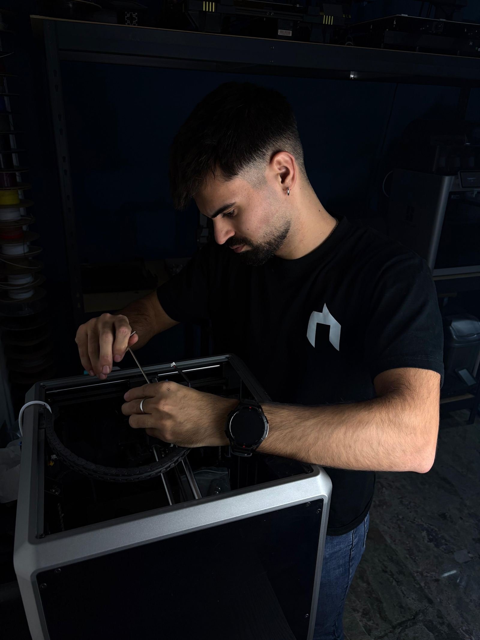 Técnico de Industria 3D revisando una impresora 3D en el taller